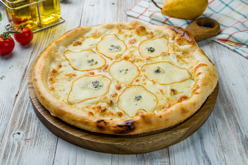 Pizza with pears and Gorgonzola cheese on white wooden table