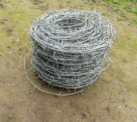 A roll of barbed wire over natural background