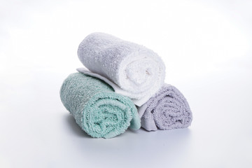 Obraz na płótnie Canvas Bath accessories. Hygiene products. Multi-colored bath towels in a roll on a white background.
