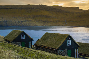 Fototapeta na wymiar Scenic landscape view of traditional historic stone wooden house/building with grass (turf) roof in Vágar Island. Tourist popular attraction/place in Faroe Islands (Denmark)
