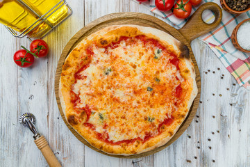 Pizza Quattro formaggi on white wooden table