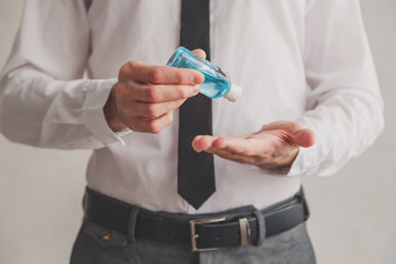 Office worker using tube of hand sanitizer gel dispenser, coronavirus Covid-19 at public places. Antiseptic, Hygiene and healthcare concept