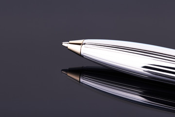 Luxury silver colored ball pen isolated on dark background. copy space. Signature, agreement, businessman concept.