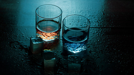 glasses of water on blue background with ice whisky and gin