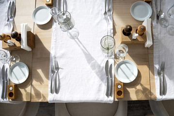 Served table. Aesthetic pleasure. .Glasses, flower fork, knife served for dinner in restaurant with cozy interior