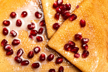 Pancakes with pomegranate and condensed milk. Macro. Top view.
