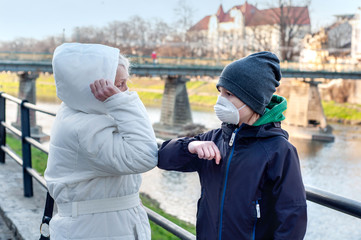 Grandmother and grandchild greet shaking elbows outdoors. People greeting together by new style for prevent coronavirus covid-19. Don't shake hands. Elbow greeting style. Stop handshakes.