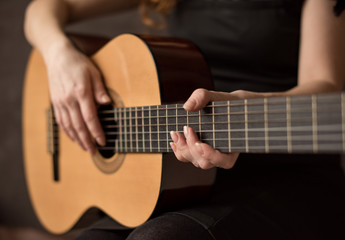 Female hands with a guitar close-up