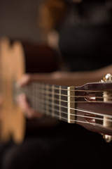 Female hands with a guitar close-up