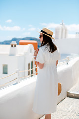 Fototapeta na wymiar girl in a white dress in sunglasses and a straw hat looks away