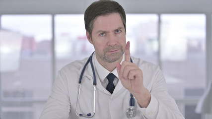 Portrait of Middle Aged Doctor saying No with Finger Sign