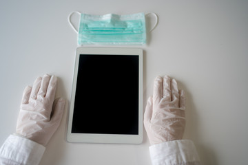 Close up on hands in medical gloves using tablet computer. Protective care. Emergency problem. Healthcare employee practitioner, distance working and learning concept. Modern technology background.