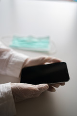 Close up on hands in medical gloves using mobile smart phone. Protective care mask. Emergency problem. Healthcare employee practitioner, distance working learning concept. Modern technology background