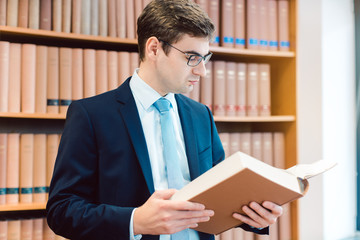 Lawyer in his office reading precedents in thick books