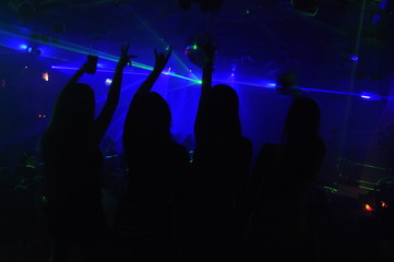 Fototapeta na wymiar Silueta de tres mujeres bailando en club nocturno / Silhouette of three women dancing in night club