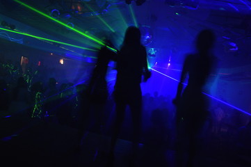Fototapeta na wymiar Silueta de tres mujeres bailando en club nocturno / Silhouette of three women dancing in night club