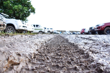 Huella de neumático en el fango con autos en desenfoque / tire track in the mud with cars in blur