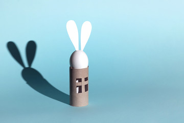 Easter egg bunny on self-insulation. In the toilet paper cabin. A concept on quarantine and pandemic