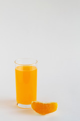 glass of fresh orange juice with slice of orange on the white background. vitamin C to strengthen the immune system. Healthy lifestyle. copy space. vertical