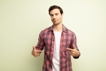 young handsome man looking proud, arrogant, happy, surprised and satisfied, pointing to self,...