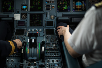 Pilot's hand dialing in flight values in  a commercial airliner airplane flight cockpit during...