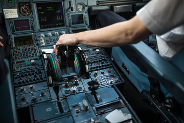 Fototapeta na wymiar Pilot's hand accelerating on the throttle in a commercial airliner airplane flight cockpit during takeoff