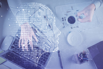 Double exposure of man's hands typing over computer keyboard and brain hologram drawing. Top view. Ai and data technology concept.