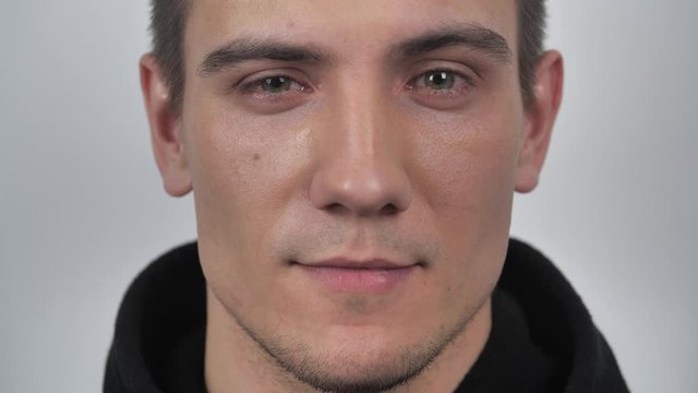 Handsome man looking at camera approvingly nodding on white background. Portrait of satisfied young man. 4k