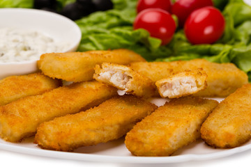 Fototapeta premium Appetizing fried fish fingers with vegetables