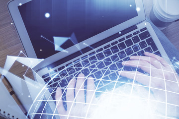 Multi exposure of man's hands typing over computer keyboard and world map hologram drawing. Top view. Technology concept.