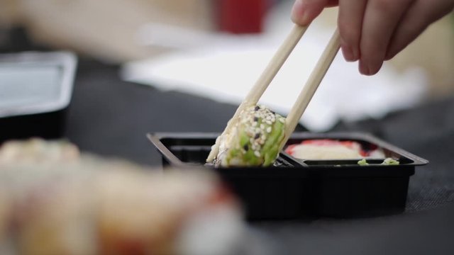 chinese chopsticks take sushi roll