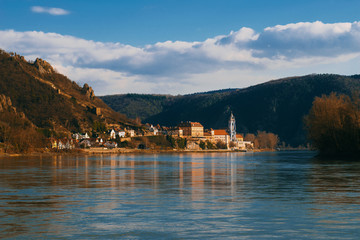 Photo of a small village bathed in sunlight near Danube river in Austria. Places t see while traveling.