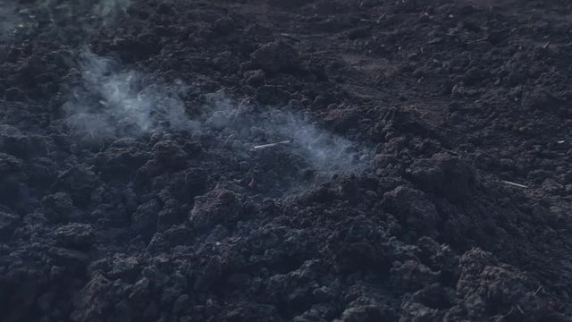 Explosion on the surface of the earth from an explosive device, hit by a shell or ammunition, the texture of smoke and flying soil from the shock wave in slow motion, the soil during combat