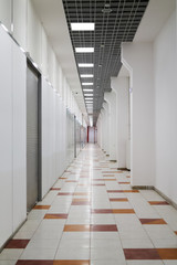deserted mall corridor with closed retail space, vertical frame