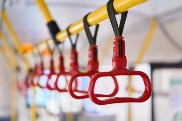 interior elements of public transport - city bus grab handles - on a blurred background