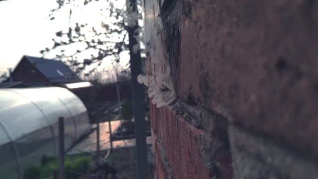 A bullet or projectile hits a brick or wooden wall, and ammunition ricochets off the wall with flying fragments in slow motion
