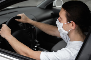 Man in protective medical mask for protect himself from bacteria and virus is planning to drive a...