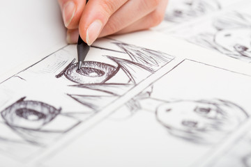 Artist drawing an anime comic book in a studio. - 334870241