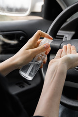 Woman is using antiseptic for protect himself from bacteria virus while planning to drive. Antiseptic while quarantine, pandemic, covid 19, coronavirus, infection.