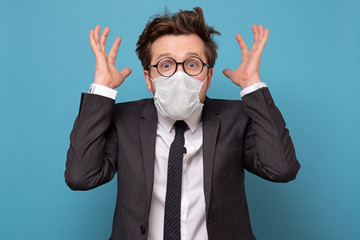 Stressed caucasian man in medical mask and glasses screams in panic