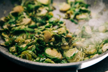 A pan full of  sau·téed shaved brussel sprouts as a vegetarian side dish for dinner