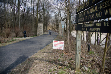 A COVID-19 park closed warning sign posted at the entrance  to the little turtle walking trail in logansport 