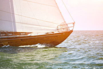 Wooden sailing yacht is sail in the waves during race.
