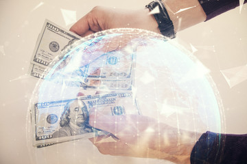 Multi exposure of financial theme drawing hologram and USA dollars bills and man hands. Business concept.