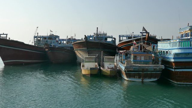 Left to right pan of Iranian launch Lenj fishing boats in a harbour in the strait of Hormuz