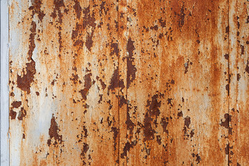 rust stained wall with cracked peeling off white enamel paint