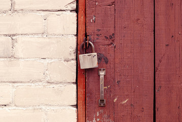 old brown wooden door locked with padlock