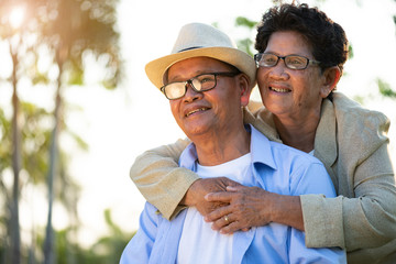 A happy senior couple asian old man and woman smiling and laughing in the garden, happy marriage. Senior healthcare and relationship concept.