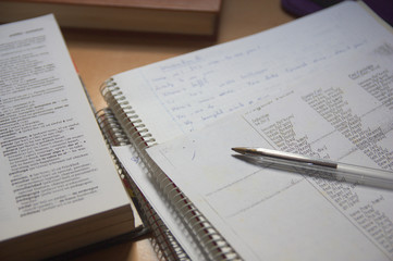 A table with the homework and books of an English language learner