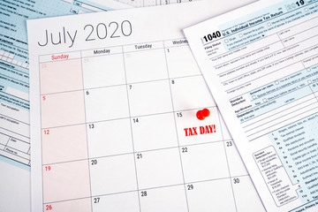 Postponed tax return deadline day to wednesday 15 july 2020 due to the covid-19 corona virus crisis. Day pinned with red pin, 1040 tax forms on the sides. 